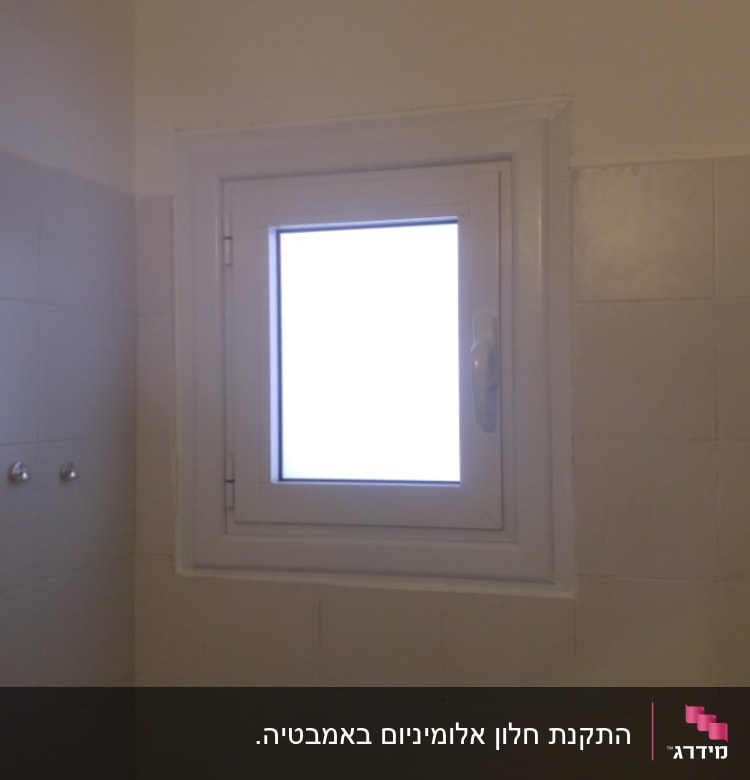 חלון אלומיניום עם מסגרת לבנה וקיר אריחים